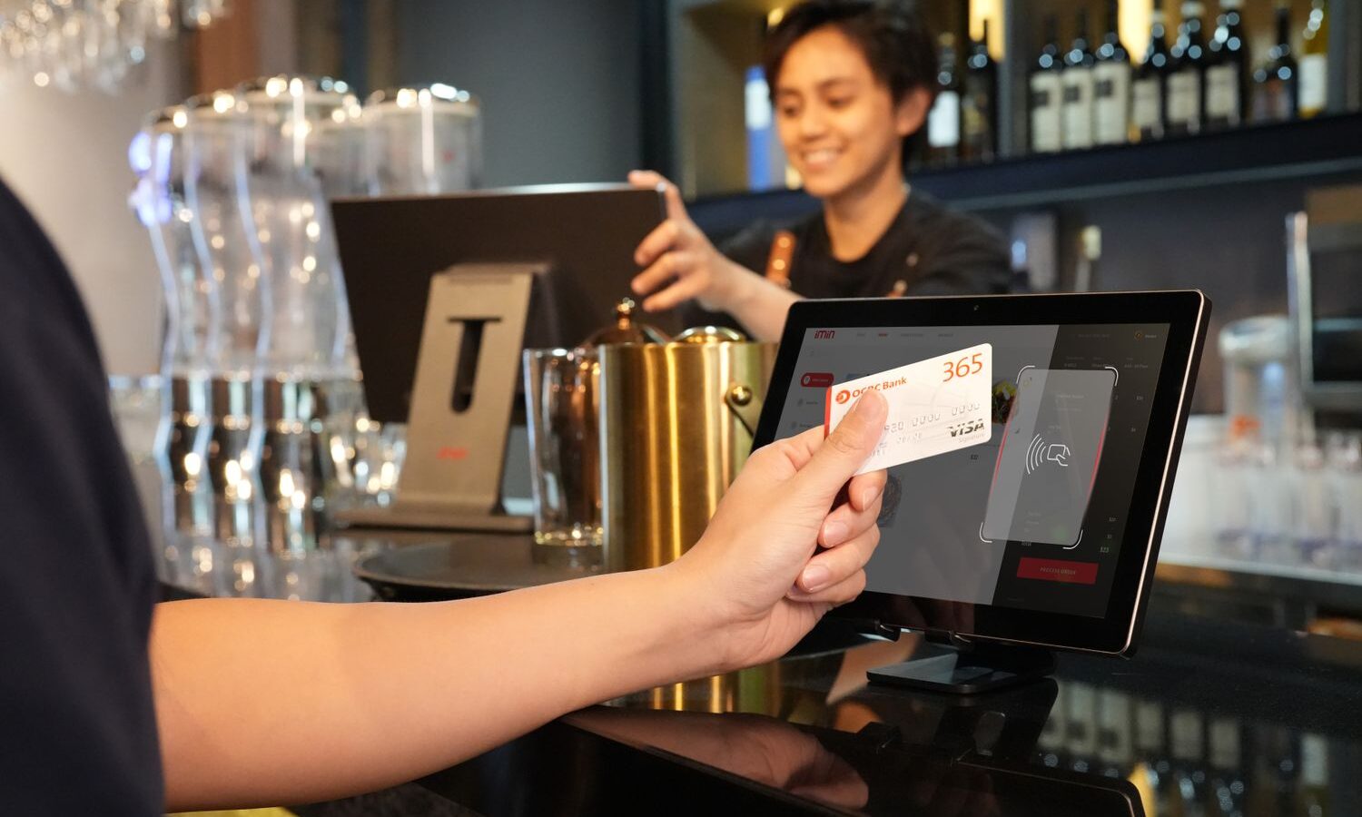 Cliente pagando com cartão em máquina no balcão do restaurante
