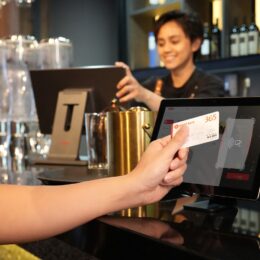 Cliente pagando com cartão em máquina no balcão do restaurante