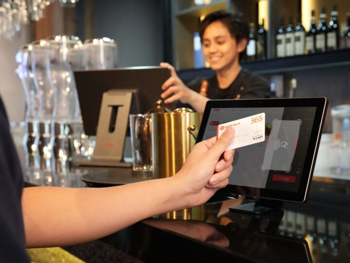 Cliente pagando com cartão em máquina no balcão do restaurante