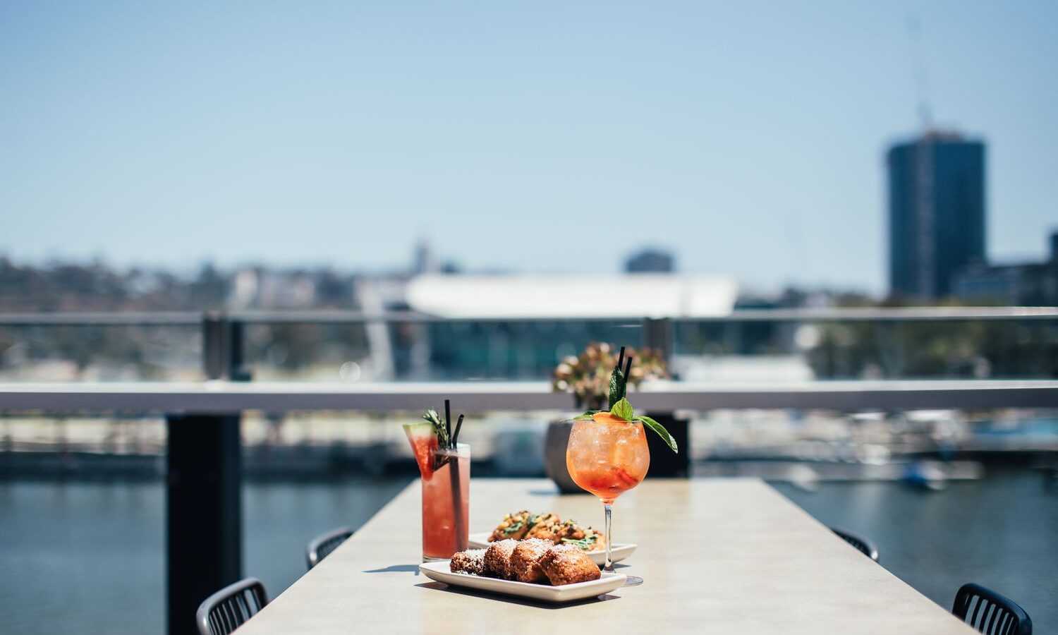Mesa de restaurante ao ar livre com comida e bebidas geladas no verão