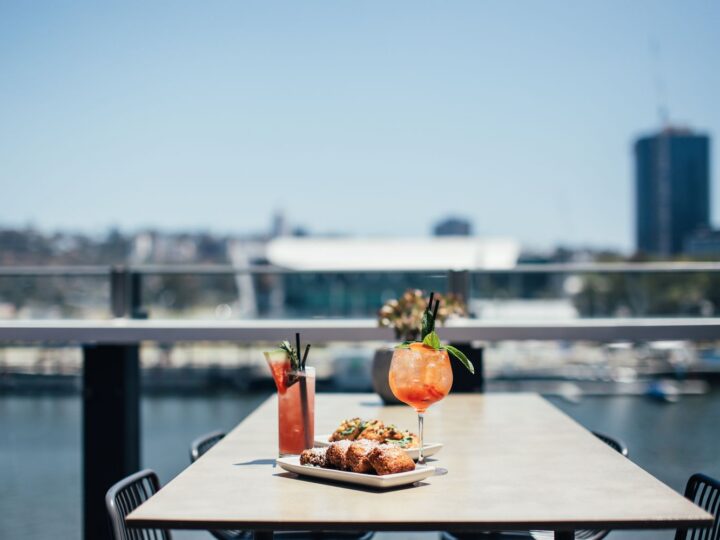 Mesa de restaurante ao ar livre com comida e bebidas geladas no verão