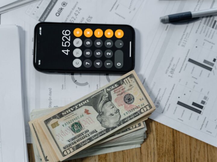 Dinheiro e calculadora sobre relatório para calcular o retorno do investimento