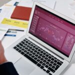 Notebook mostrando gráficos de vendas sobre uma mesa