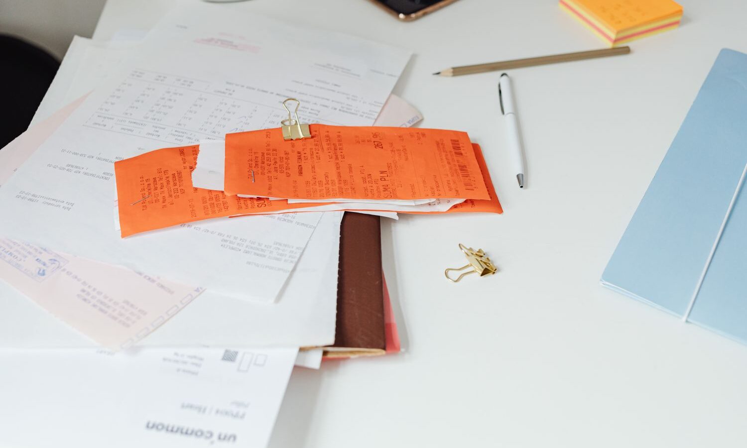 Recibos e documentos sobre a mesa para organizar contas a pagar
