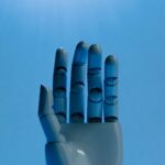 Mão robótica azul sobre fundo azul